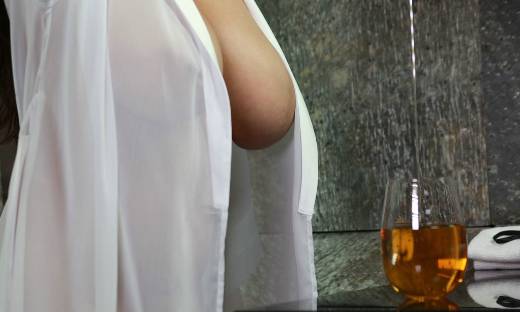 Large breasts in sheer robe and a glass of honey